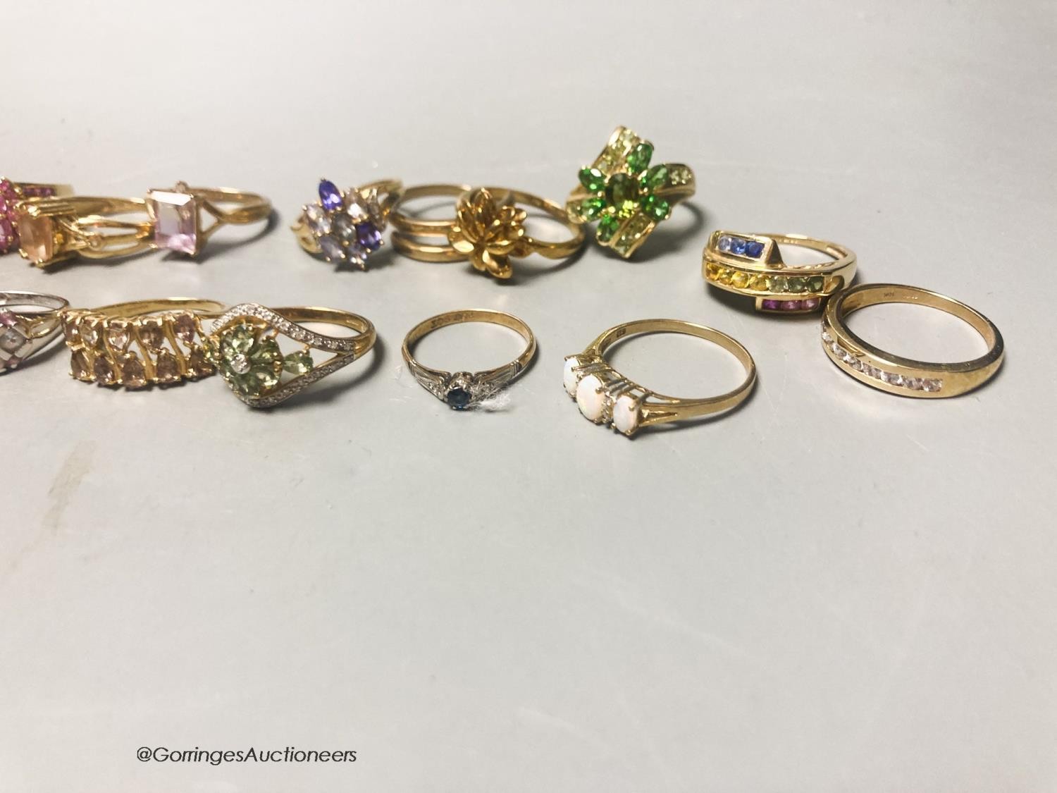 Twenty assorted modern 9ct or 9k and gem set dress rings, gross 66.4 grams.